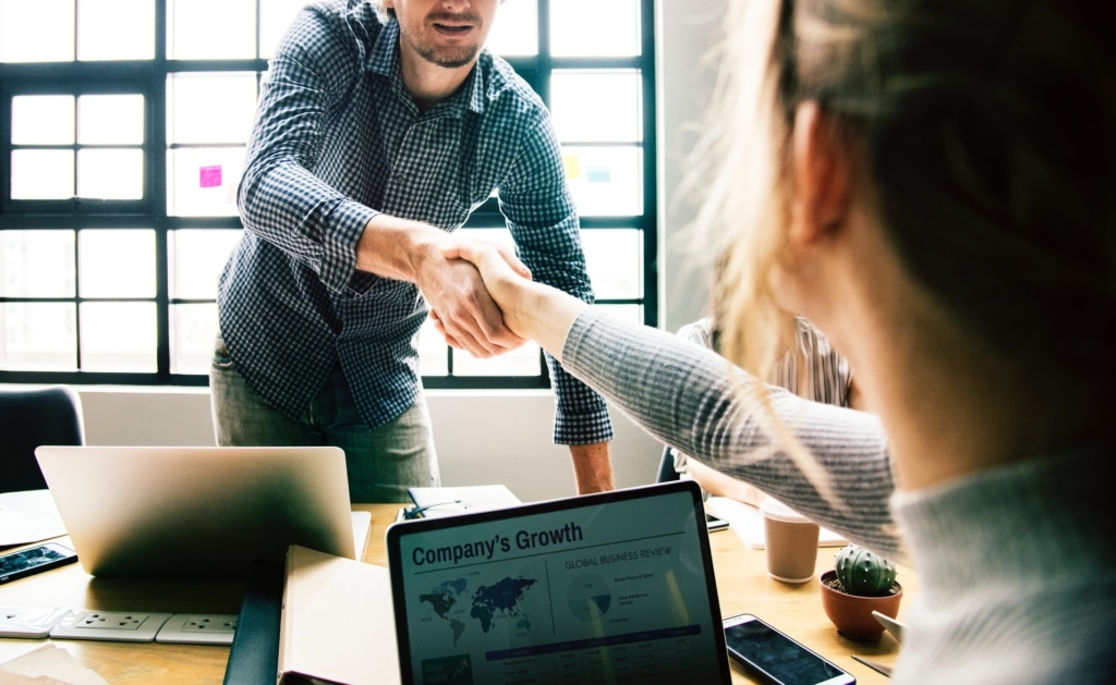 A man and a woman shaking hands in an office