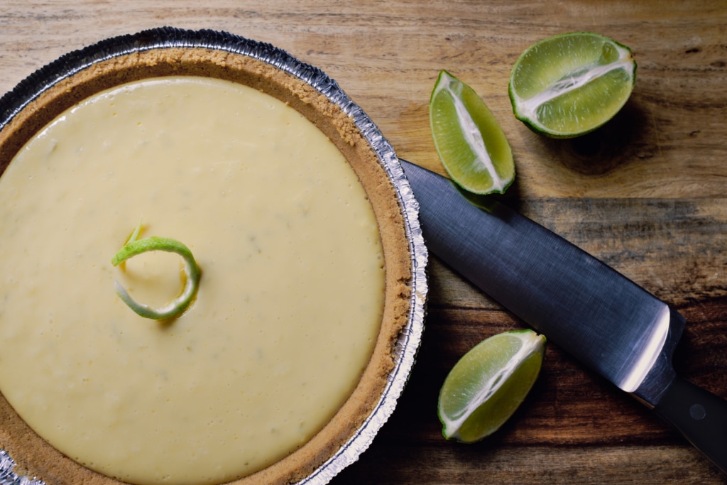 key lime pie on table with sliced limes